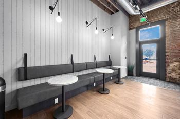 A room with a long bench and a table with a plant on it.